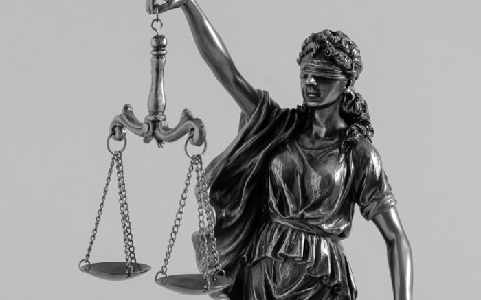 Statue of Lady Justice holding balanced scales with a blindfold